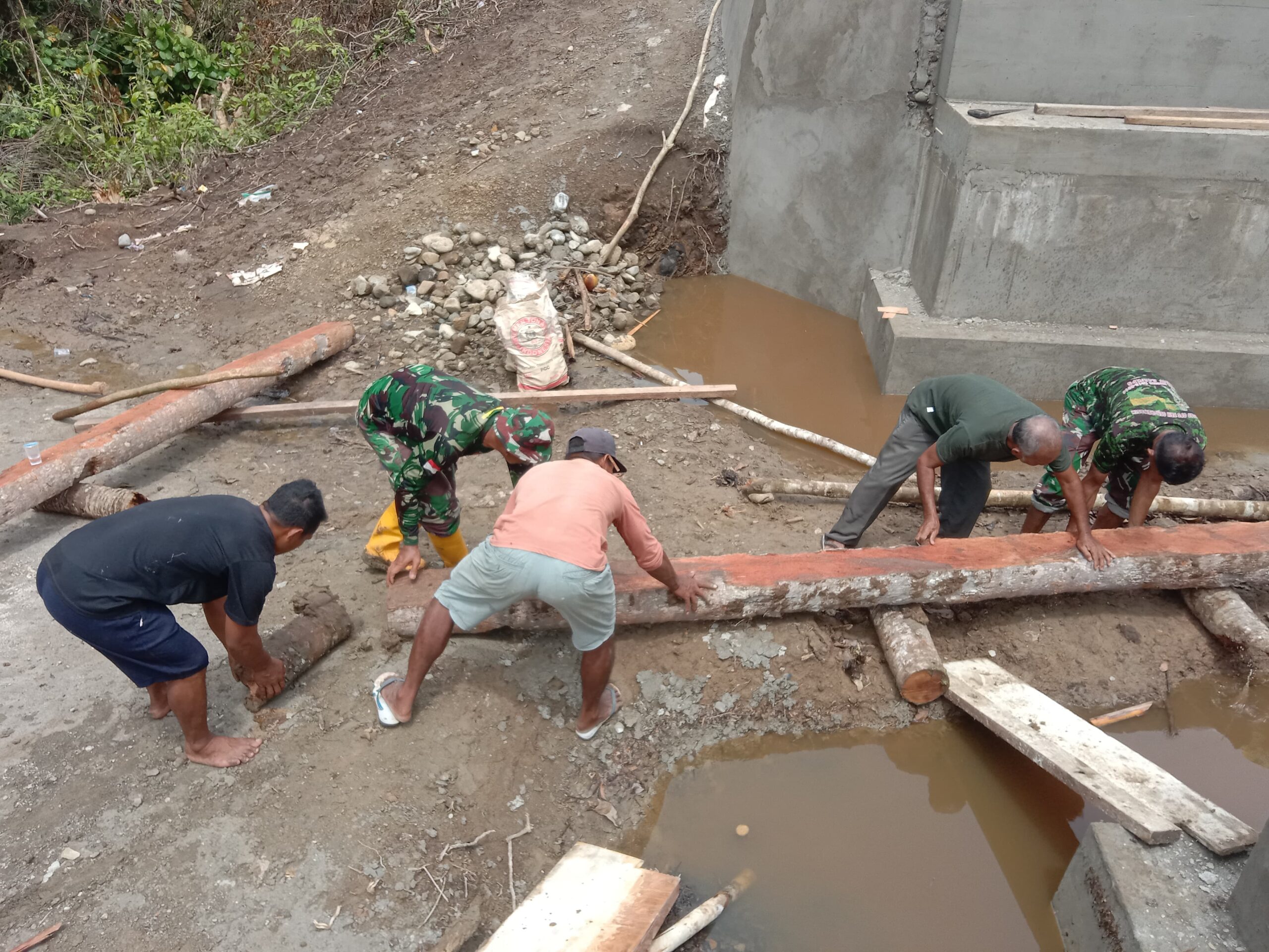 Anggota Kodim 1505/Tidore Bersama Warga Gotong Royong Angkat Batang Kelapa untuk Penahan