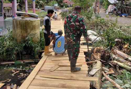 Babinsa Koramil 1002-05/Pandawan Gotong Royong Bantu Warga Perbaiki Titian di Desa Kayu Rabah